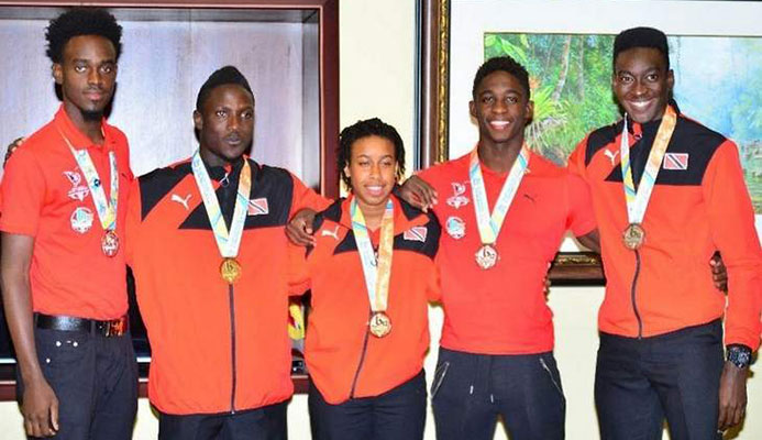 MEDAL STARS: Trinidad and Tobago's four individual medal winners and the captain of the gold medal-winning Girls beach soccer team pose with their Commonwealth Youth Games hardware at the VIP Lounge at Piarco International Airpot Tuesday night upon the team's return home from the Nassau, Bahamas event. From right are Tariq Horsford (silver) Jeron Thompson (bronze), Nia Honore (gold), Adell Colthrust (gold) and Jabari Grey (silver). —Photo: STEPHEN DOOBAY