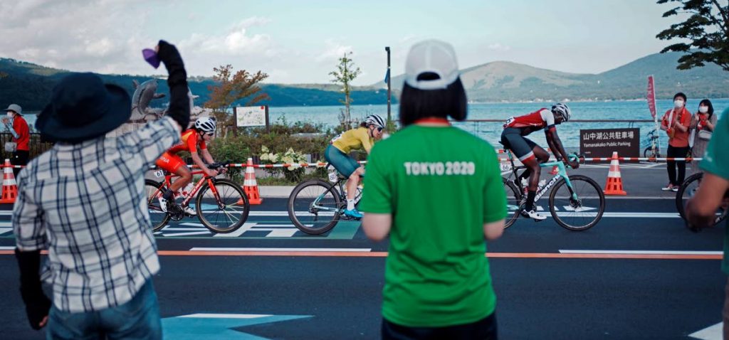 Fans watch as Teniel Campbell of Trinidad and Tobago, right, Amanda Spratt of Australia, centre, and Jiajun Sun of China, left, compete during the women's cycling road race at the 2020 Summer Olympics, Sunday, in Oyama, Japan. (AP) -