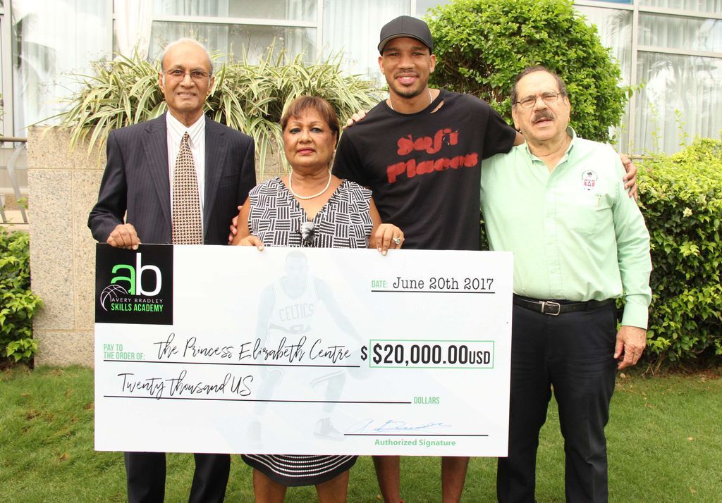 Point Guard from NBA’s Boston Celtics Avery Bradley, second from right, presents a US$20,000 cheque to the Princess Elizabeth Centre toward the construction of the Centre’s new orthopedic wing. The donation will be matched by the US National Basketball Players Association (NBPA). Also in photo from left are Dr Calvin Inalsingh, president of the Board of Directors of the Princess Elizabeth Centre, Jan Sirjusingh, CEO of the Princess Elizabeth Centre, and Prof Clement Imbert, vice president of the Board of Directors of the Princess Elizabeth Center. picture courtesy US Embassy (Image obtained via: guardian.co.tt)