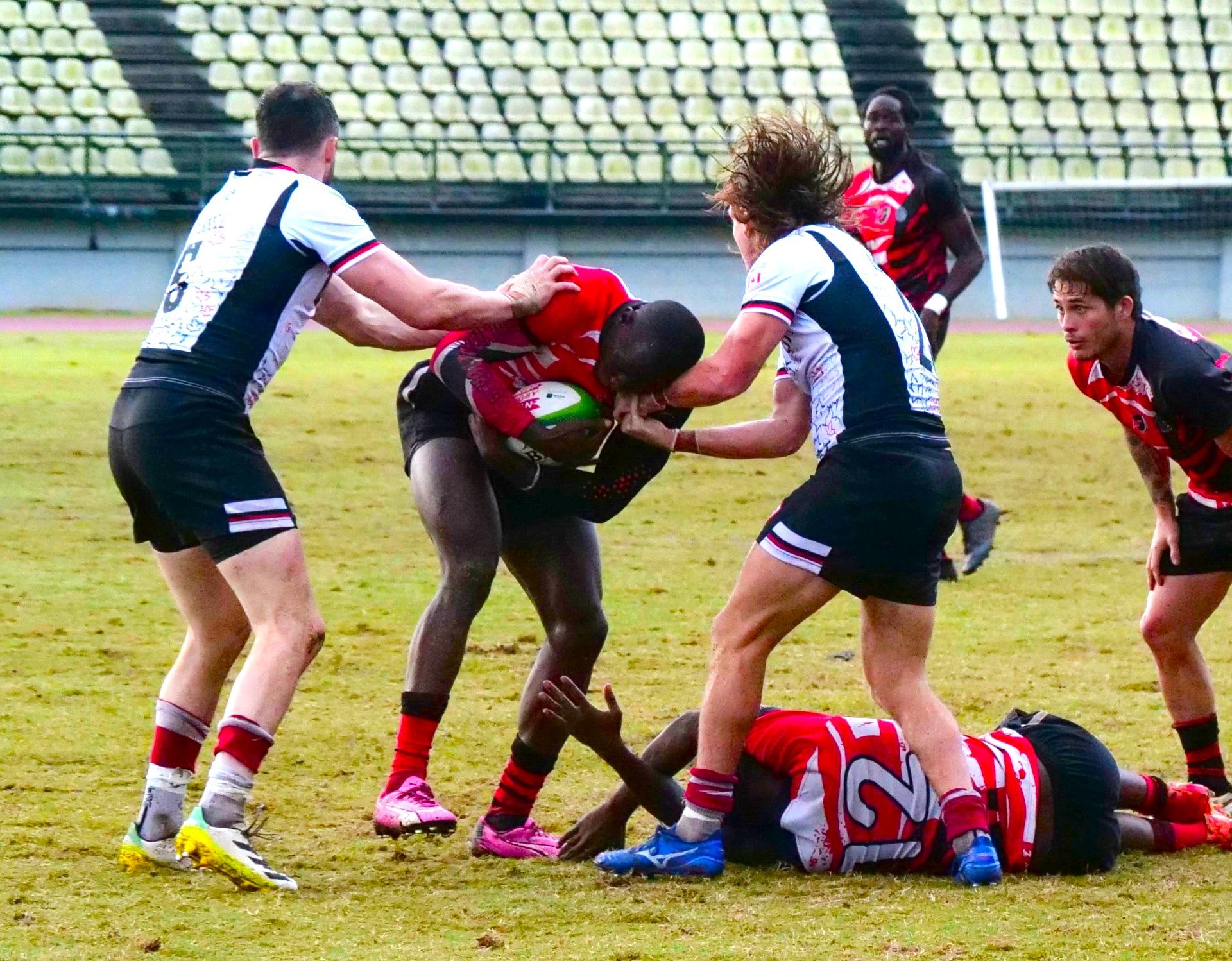 T&T captain Shakeel Dyte attempts to push through the Canada defensive line, Alex Russell and Thomas Isherwood during the men’s final in the RAN Sevens Tournament at Larry Gomes Stadium in Malabar, Arima, yesterday. T&T suffered a 38-0 loss.  ROGER JACOB (Image obtained at guardian.co.tt)