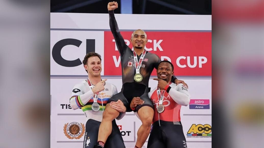 HOMETOWN HERO: TTO’s Nicholas Paul, right, combines with the Netherlands’ Harrie Lavreysen, left, to lift Malaysia’s Azizulhasni Awang, who was crowned champion of the men’s keirin at the UCI Track World Cup in Nilai, Malaysia, yesterday. Lavreysen seized silver, while Paul bagged bronze. —Photo: TTCF (Image obtained at trinidadexpress.com)